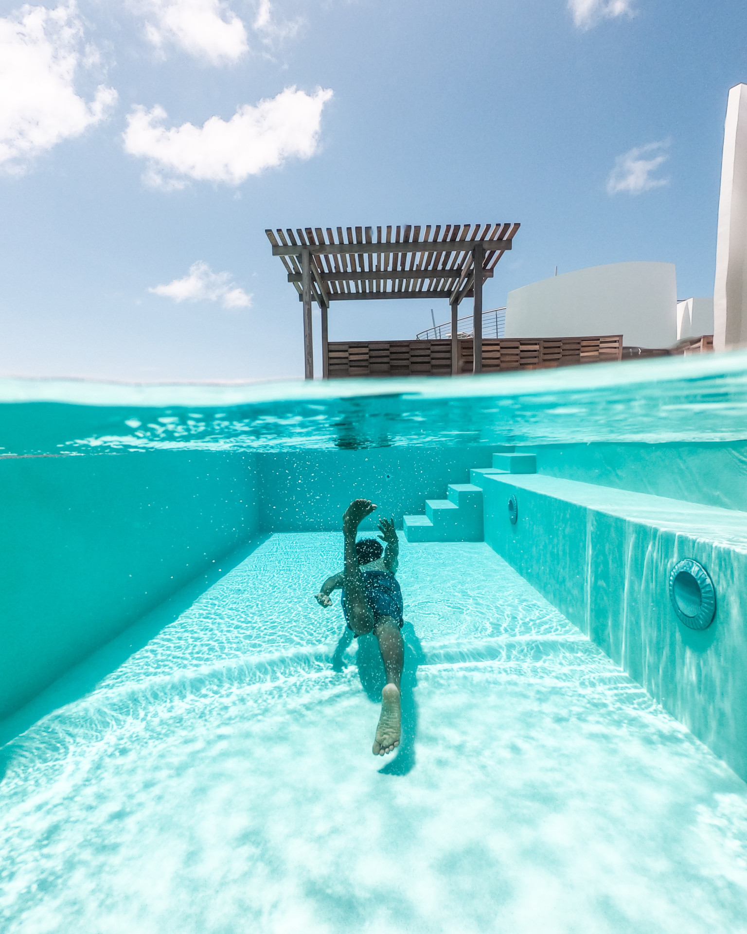 A Man swimming underwater in a pool